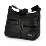 Asymmetric-zip cowhide shoulder bag OEM SKU 706FB with black leather body, front zipper pockets, curved top line, and strap